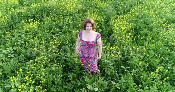 穿着红色夏装的女人光着脚在田野上行走视频的预览图