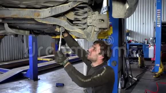 汽车机械师用扳手工具在车下工作手持的视频的预览图