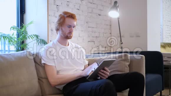 坐在红发男子桌上的网上购物视频的预览图