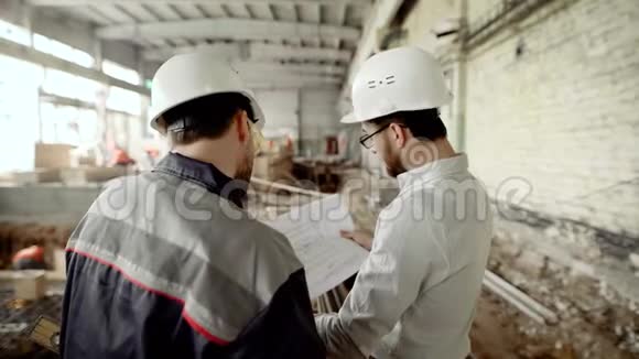 戴头盔和戴眼镜的男子站在建筑区背景是人视频的预览图