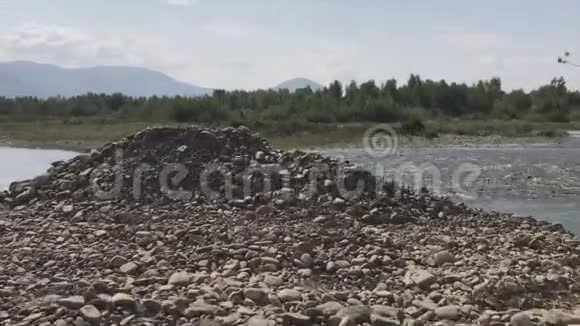 出口到一条山河的岩石海岸水流湍急地平线上有一条山链视频的预览图