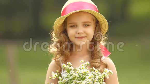 孩子手里拿着一束野花她闻着它们微笑着慢动作视频的预览图