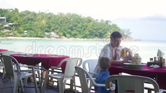 一家人在海滩上的餐馆吃饭热带岛屿视频的预览图