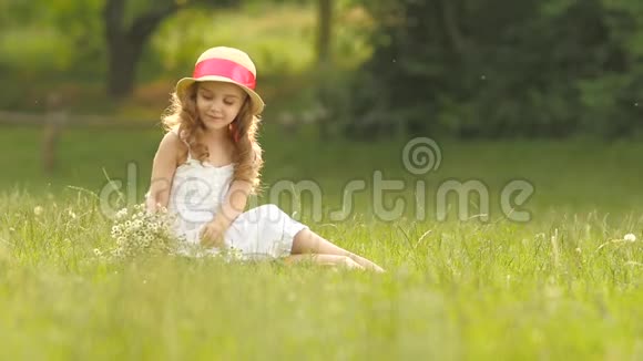 孩子手里拿着一束野花她闻着它们微笑着慢动作视频的预览图