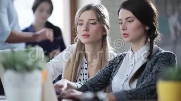 年轻成功的女商人坐在轻盈的现代办公室里看着笔记本电脑讨论着一些创业的事情视频的预览图