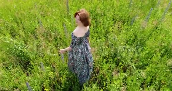 穿过一片荒野的草地的女性俯视视频的预览图