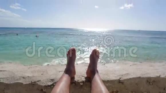 在晴朗的蓝天下人们的双脚在海边放松视频的预览图