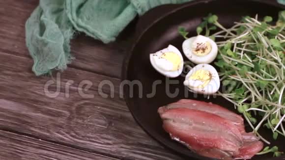 菜芽鹌鹑蛋和凤尾鱼的不寻常沙拉在铸铁锅中食用视频的预览图