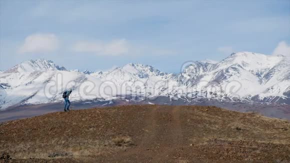 徒步旅行者女人背着背包在山顶徒步旅行女游客使用智能手机拍照或录像白雪公主视频的预览图