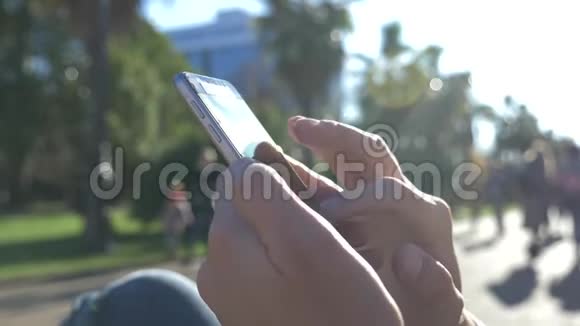 关闭一个男人使用移动智能手机户外城市里一只雄性手在智能手机上发短信视频的预览图