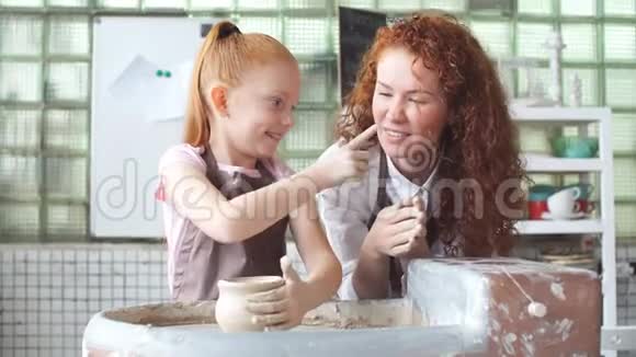 小女孩在陶轮上玩粘土玩得很开心视频的预览图