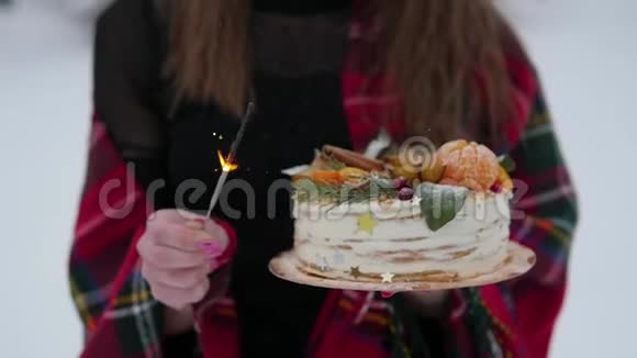 年轻女子在街上拿着圣诞蛋糕下雪了闪闪发光视频的预览图