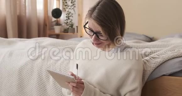 体贴的女人在家里写记事本视频的预览图