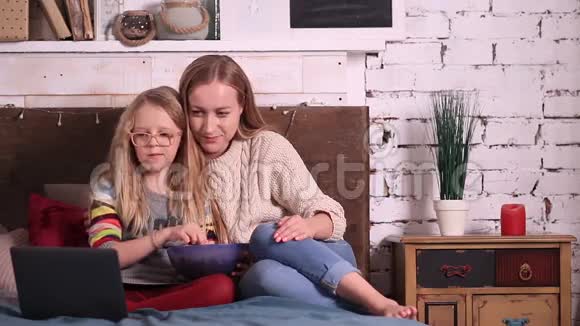 母亲和女儿在笔记本电脑上看动画片视频的预览图