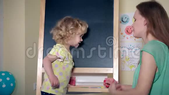 爱妈妈教孩子在家里的黑板上教字母表字母视频的预览图