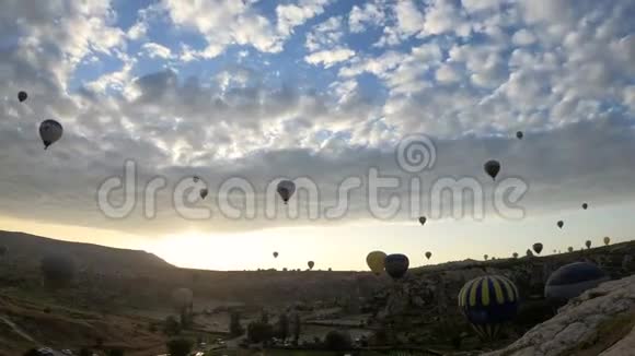 许多热气球飞过土耳其戈尔梅的山谷天空小云的时间流逝视频的预览图