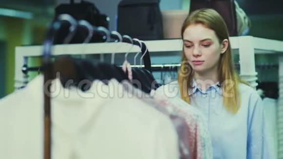 美丽的女人在精品店的衣架上买衣服视频的预览图