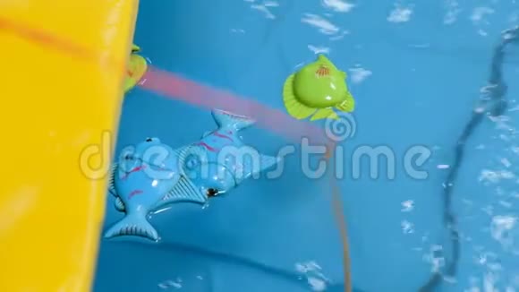 幼儿用鱼竿在水中钓玩具鱼视频的预览图