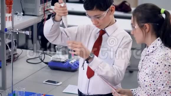 一个小学生演示如何在试管中加入化学物质视频的预览图