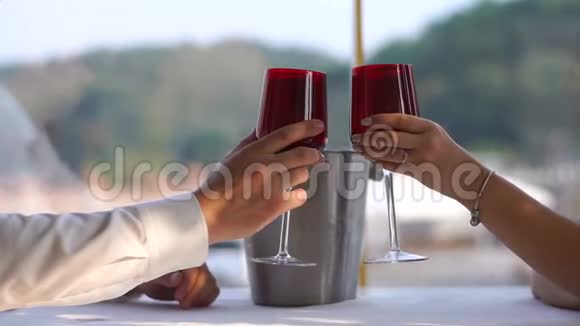 这对情侣在餐厅喝着酒碰杯的近景没有脸视频的预览图