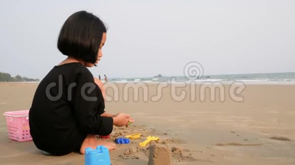 亚洲小女孩在海边沙滩上玩耍傍晚前的气氛视频的预览图