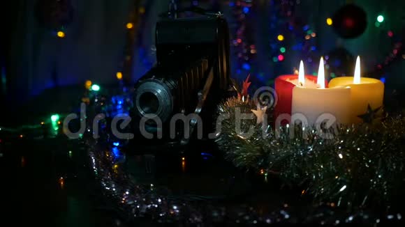 三支新年蜡烛和一台旧相机摄像机围绕物体的运动背景模糊视频的预览图