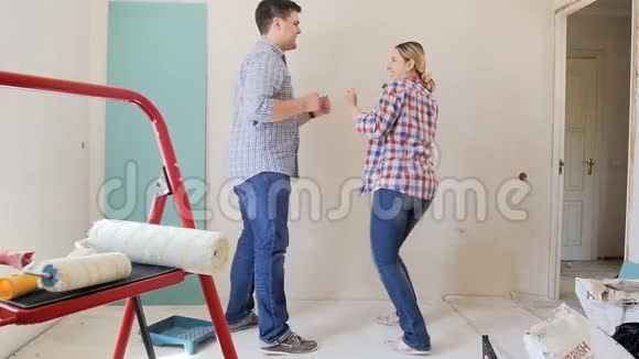 正在装修的公寓里跳舞的年轻夫妇的慢动作视频视频的预览图