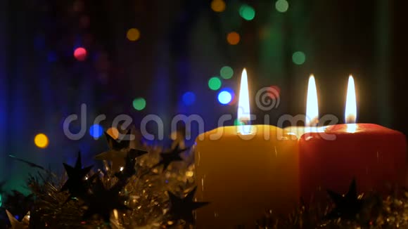 三支新年蜡烛和圣诞装饰品有彩色灯光的模糊背景从未设区出口视频的预览图