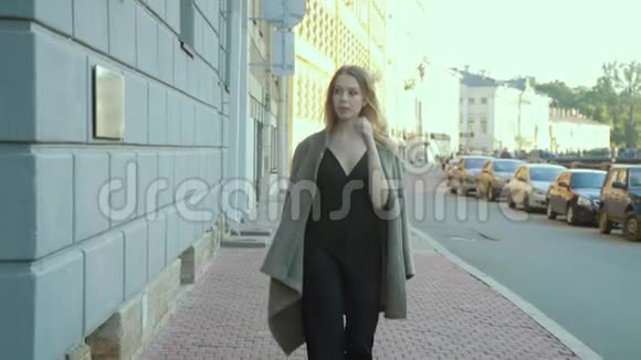 穿着时髦的鸡尾酒连衣裙的迷人女孩走在斯洛文尼亚的一条城市街道上视频的预览图