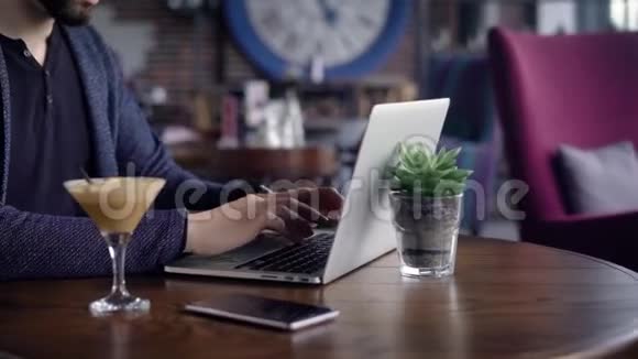 一个眼睛不好的年轻作家在他所在城市的咖啡馆里为一台笔记本电脑作品一个男人在键盘上打印诗歌视频的预览图