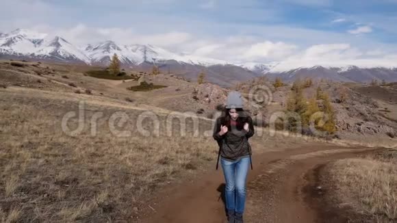 徒步旅行的女士走在山顶与背包欣赏山景景观迷人的女性旅行者视频的预览图
