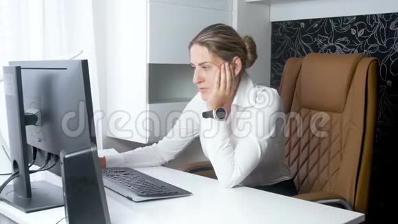 漂亮的女商人坐在大皮椅上用电脑办公视频的预览图