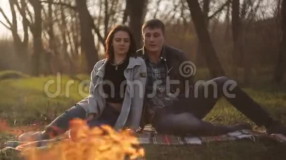 一对相爱的年轻夫妇在火边约会那个男人和那个女孩欣赏火焰视频的预览图