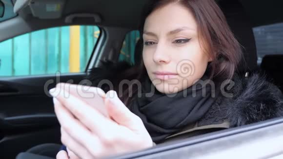 坐在车里用智能手机拉近女孩的距离视频的预览图