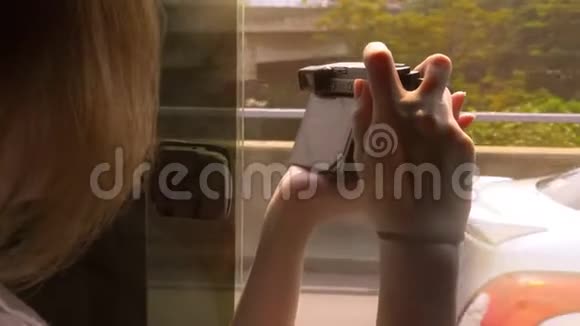 一个女人从一辆现代汽车上拍摄摩天大楼的照片视频的预览图