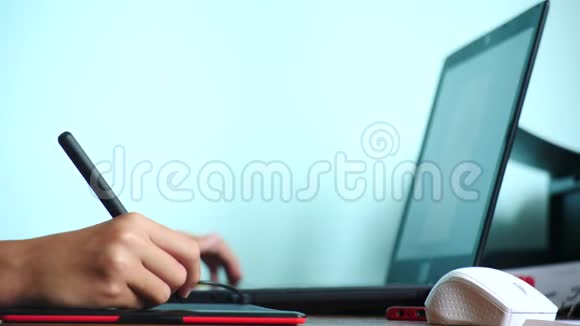 特写镜头女孩画在一个图形平板上自由职业一只手拿着笔在红色的黑色平板上移动4k慢动作视频的预览图