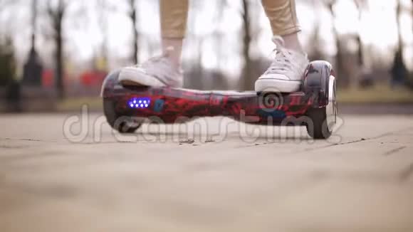 少女在智能滑板车上旋转电子滑板车上的脚特写视频的预览图