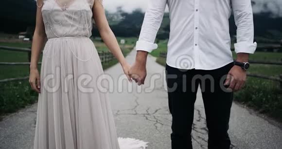 这对打扮浪漫的年轻情侣牵着彼此的手背景令人惊叹的自然景观视频的预览图