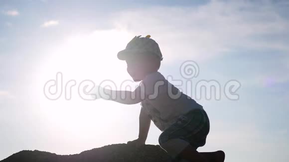 快乐的孩子在阳光下在岩石上玩耍视频的预览图