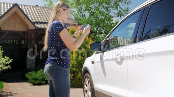 4k段年轻女子在智能手机上为出售汽车拍照视频的预览图