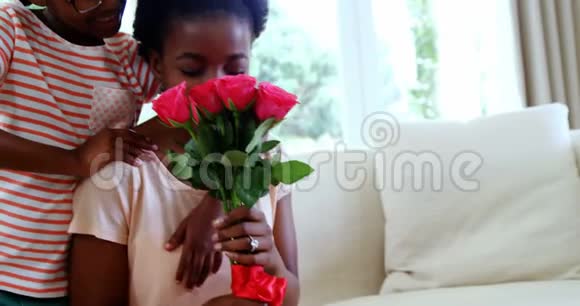 女儿在客厅给妈妈送一束玫瑰视频的预览图