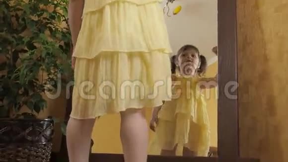 一个穿着妈妈的小女孩在镜子旁鞋子一个穿黄色连衣裙的漂亮孩子倒映在镜子里成年儿童视频的预览图