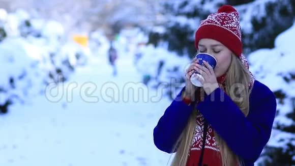 在寒冷的冬天微笑着喝咖啡的年轻女人视频的预览图