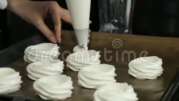 糕点厨师把奶油挤在烤盘上视频的预览图