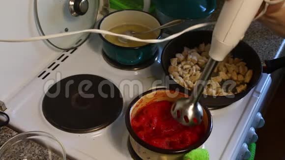 那个人用平底锅把搅拌机里的西红柿磨碎了煎锅附近有炸鸡片还有锅里煮的视频的预览图
