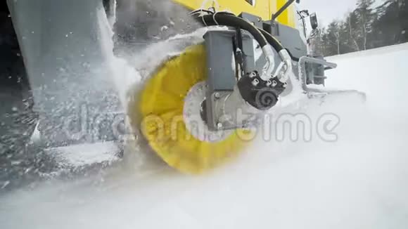 黄刷的冰雪清除卡车正在旋转和清除道路上的雪轮式收割机械视频的预览图
