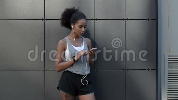 年轻的运动女性使用智能手机视频的预览图