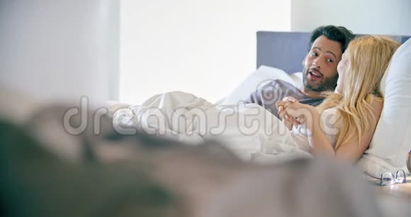 金发女人和男人睡觉后说话恋爱中的情侣在卧室里醒来高加索女朋友和视频的预览图