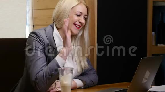 商务女性在咖啡厅的笔记本电脑视频链接上发言视频的预览图