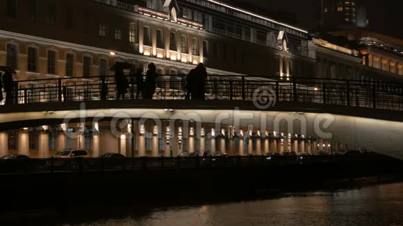 晚上在桥上散步的人的剪影城市生活视频的预览图